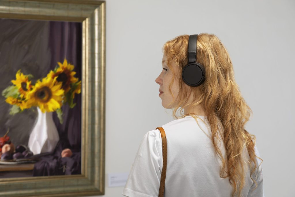 frau-von-der-seitenansicht-mit-kopfhörern-auf-der-art-galerie-skaliert-1